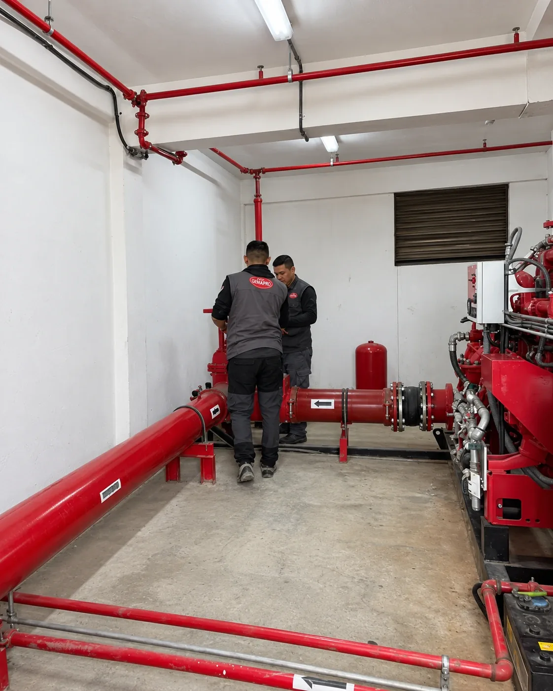 Techniciens dans le local de pompes incendie GEMAPRO, photographie retouchée